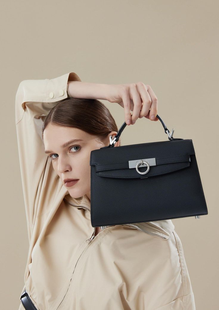 Inspired by Grace Kelly's enduring style, the Grace Top Handle Bag is meticulously crafted from premium USA full-grain textured calfskin leather, ensuring both durability and elegance. Its timeless and versatile design features a thoughtfully structured interior that comfortably accommodates all your everyday essentials. Whether day or night, you'll find yourself instinctively reaching for this chic and easy-to-wear masterpiece. Light Luxury Leather Bag With Detachable Handle, Light Luxury Leather Box Bag With Top Handle, Light Luxury Formal Crossbody Bag, Classic Box Bag With Palladium Hardware, Light Luxury Crossbody Bag For Formal Occasions, Everyday Light Luxury Leather Bags, Light Luxury Leather Bag With Top Carry Handle, Timeless Shoulder Bag With Top Carry Handle, Epsom Leather Business Shoulder Bag