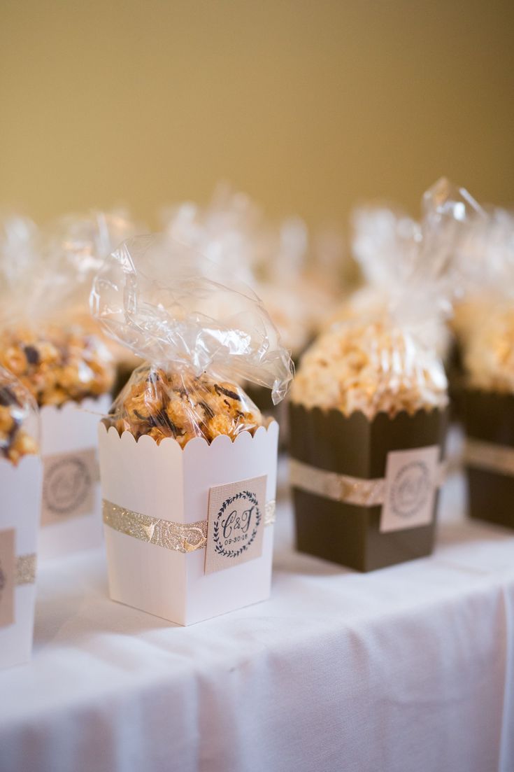 small boxes filled with popcorn sitting on top of a white table cloth covered tablecloth