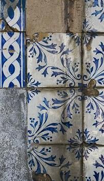 an old blue and white tile design on the side of a building with peeling paint