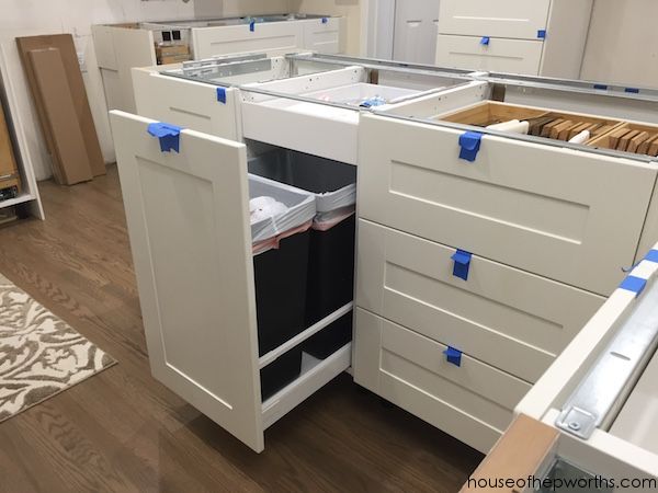 kitchen cabinets with blue tape on the handles and drawers are shown in an empty room