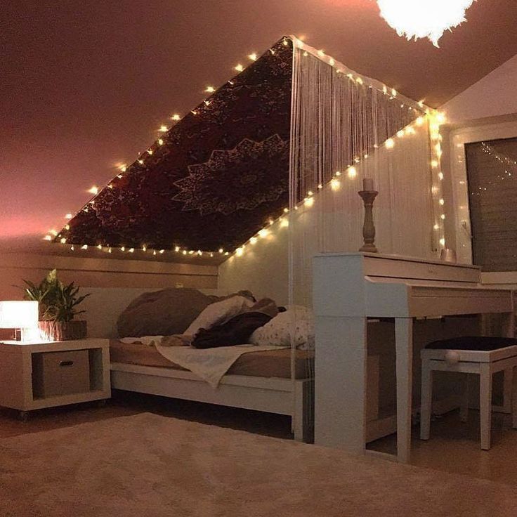 a bedroom with lights on the ceiling and a bed in it's corner area