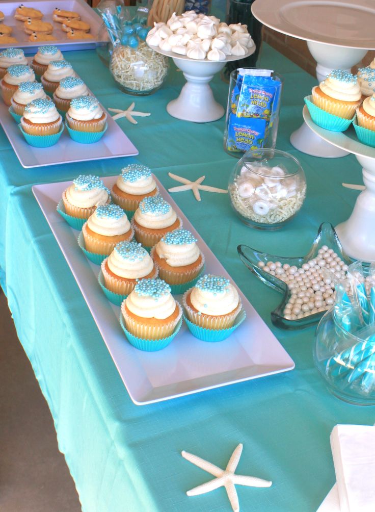 a table topped with lots of cupcakes and other dessert items on top of it