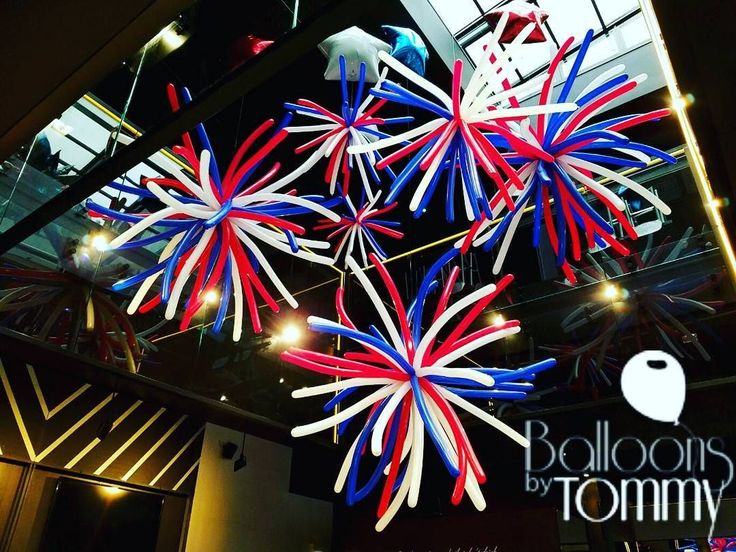 red, white and blue fireworks are hanging from the ceiling