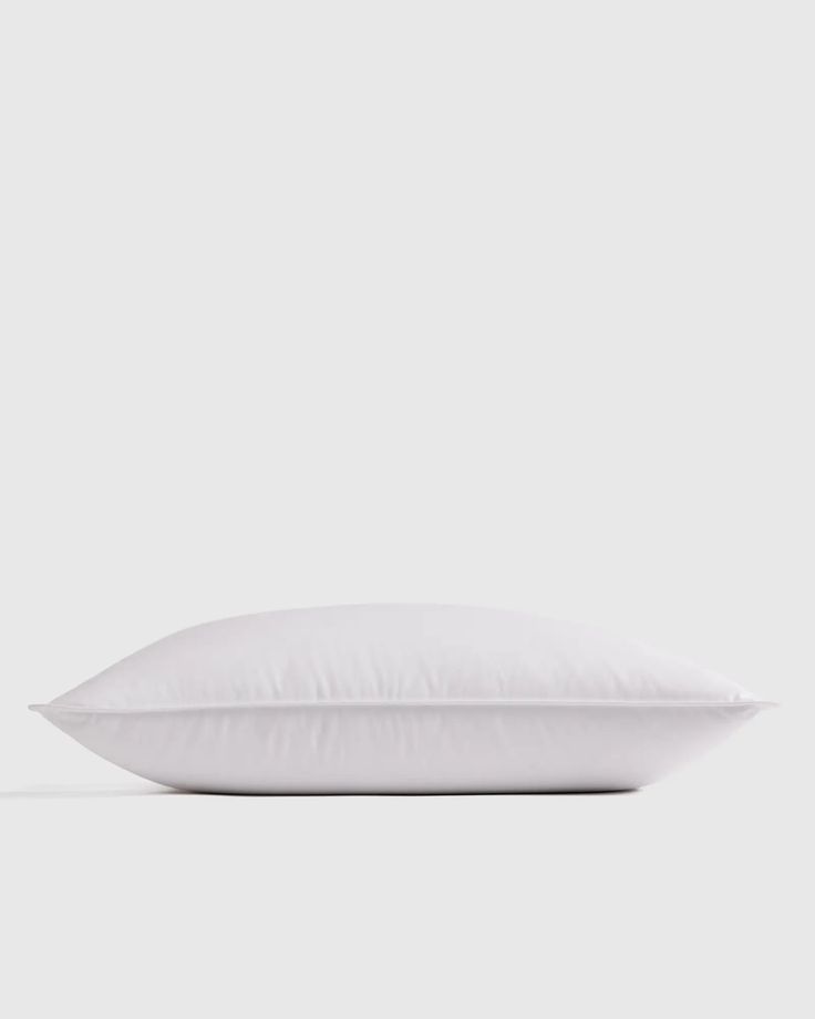 a white pillow sitting on top of a bed