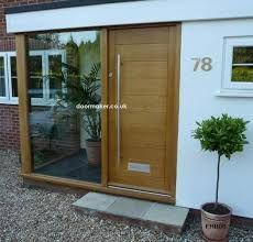 a house with a wooden door and glass windows on the outside, next to a potted plant