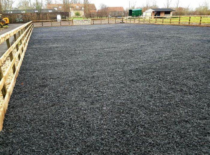 an empty parking lot is shown in the middle of a farm yard with fencing around it