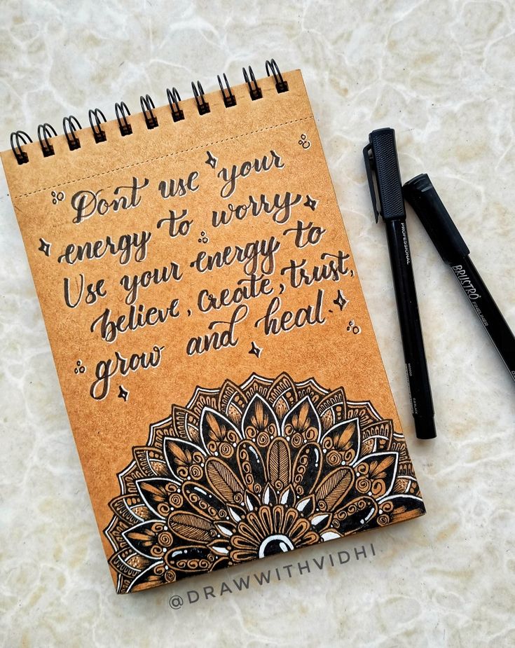 a notepad with an intricate design on it next to a pen