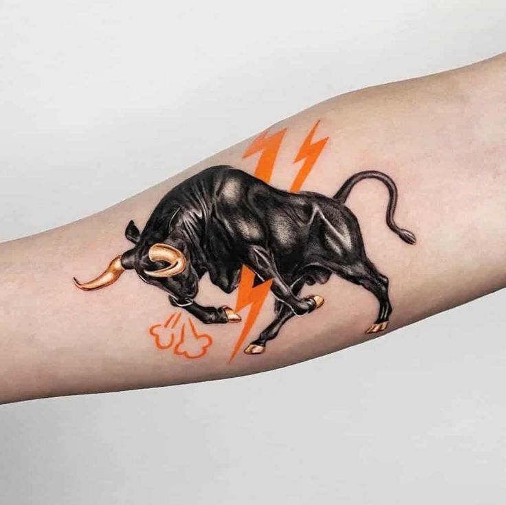 a black bull tattoo on the arm with orange lightning bolt in it's center