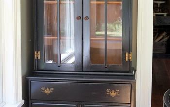 a black china cabinet with glass doors and drawers