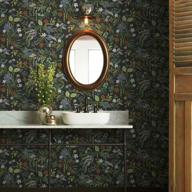 a bathroom sink sitting under a mirror next to a wall mounted faucet with flowers on it