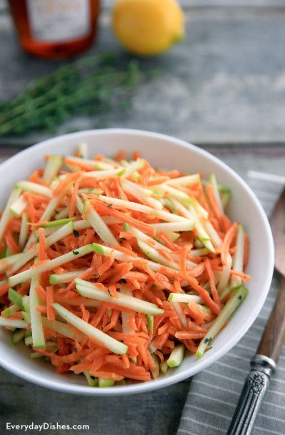 a white bowl filled with carrots and celery on top of a table