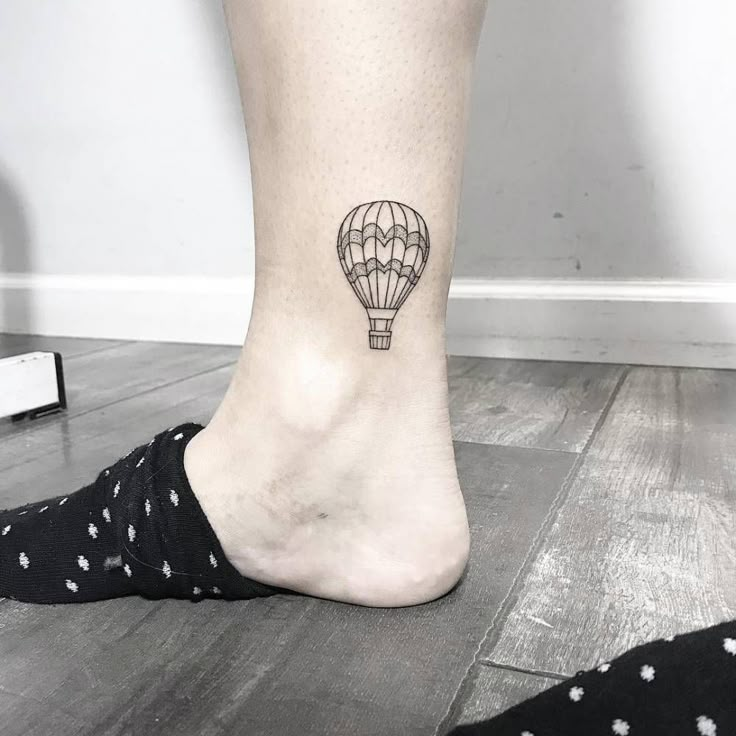 a small hot air balloon tattoo on the ankle