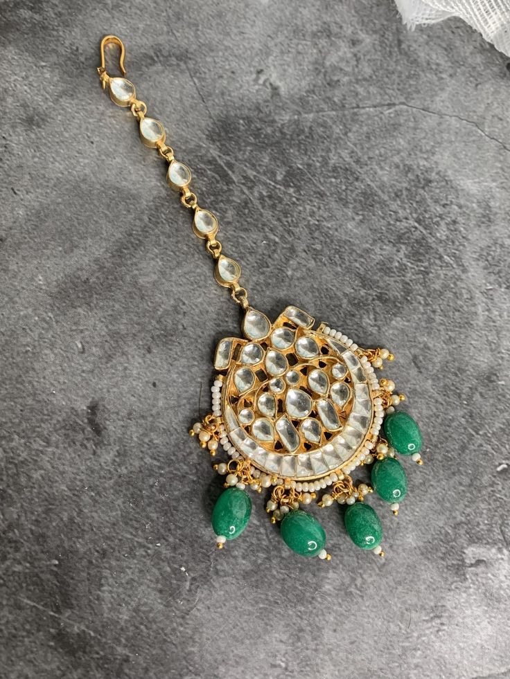 Pachi Kundan single tikka on emerald green details. About 2.5 inch in diameter. Gold plated handmade. Green Bollywood Style Tikka For Diwali, Green Tikka For Party And Diwali Festival, Festive Green Kundan Necklace With Latkans, Green Tikka With Latkans For Festivals, Bollywood Green Tikka For Festive Occasions, Bollywood Style Green Tikka For Diwali, Green Bollywood Style Tikka For Festive Occasions, Traditional Emerald Jewelry For Party, Green Round Kundan Necklace In Temple Jewelry Style