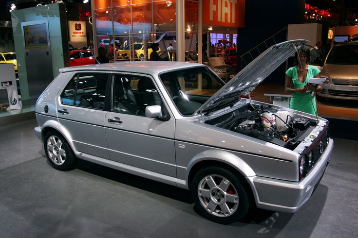 a silver car with its hood open on display