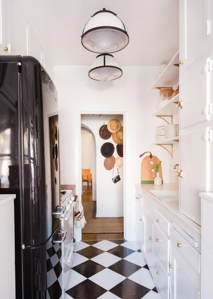 a black and white checkered floor in a kitchen with an open door that leads to another room