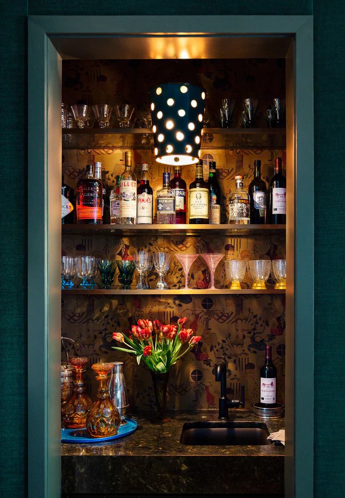 an open cabinet filled with bottles and glasses