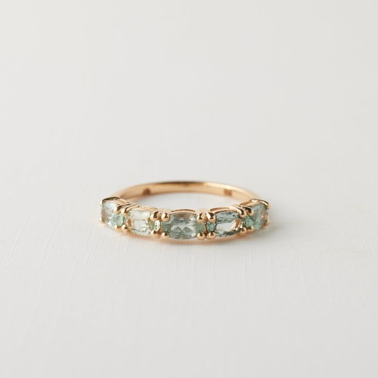 a gold ring with green stones on it