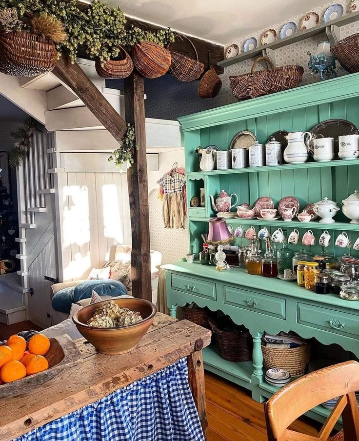 an old fashioned kitchen with green cabinets and blue checkered table cloth