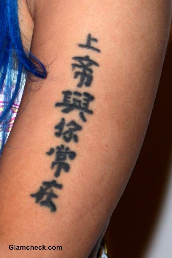 a woman with blue hair has a tattoo on her arm that says i love you