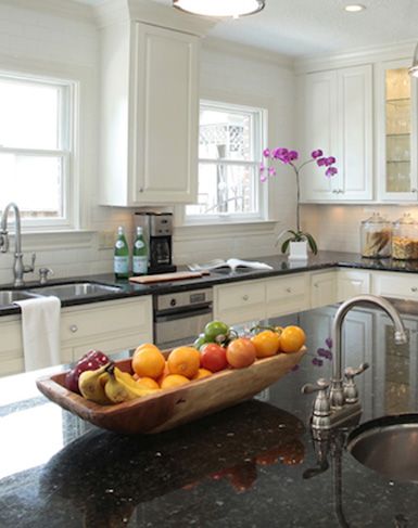 a bowl of fruit is sitting on the kitchen counter