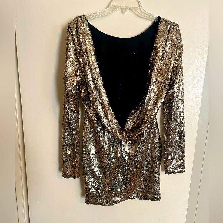 Perfect Condition, Never Worn Party Dress. Long Sleeve Backless, Sits Well At Mid Thigh. Fits Sm/Med. Gold Mini Dress For Cocktail Evening, Holiday Evening Backless Mini Dress, Gold Chic Sequin Dress For Party Season, Chic Gold Sequin Dress For Party Season, Glamorous Gold Mini Dress For Holiday Party, Chic Backless Sequin Dress For Date Night, Gold Evening Dress For Night Out, Gold Holiday Dresses For Night Out, Gold Dresses For Holiday Night Out