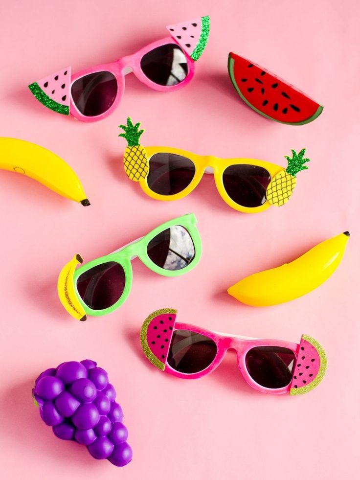 some fruit and sunglasses on a pink surface