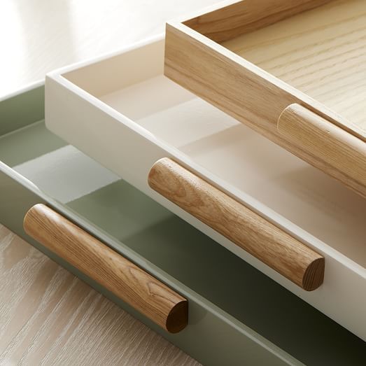 an open drawer with wooden handles on it