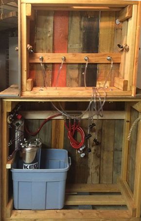 the inside of a wooden storage cabinet with tools in it and two buckets underneath