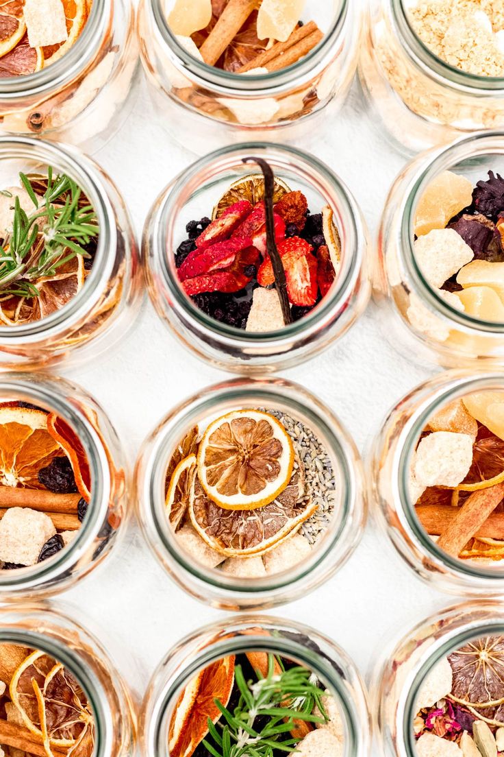 several jars filled with different types of food and spices on top of a white surface