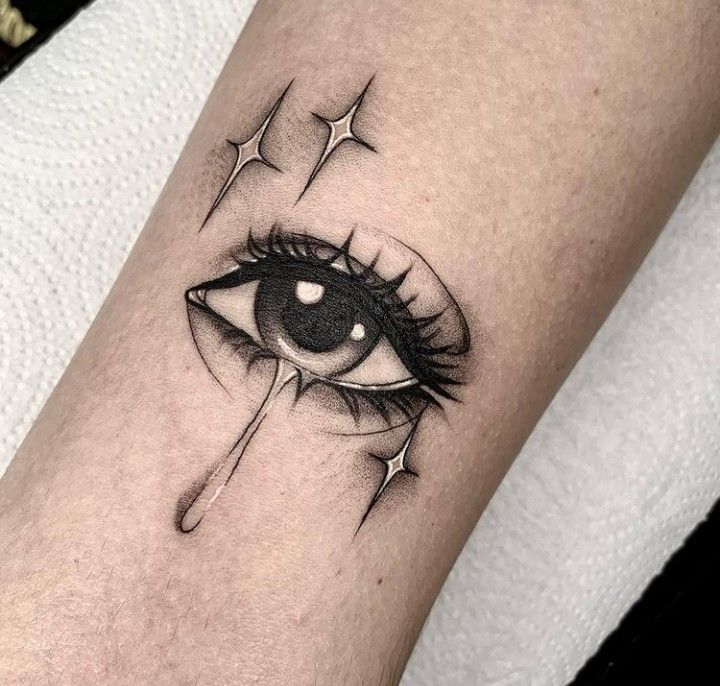 a black and white photo of an eye with tears on it's side tattoo