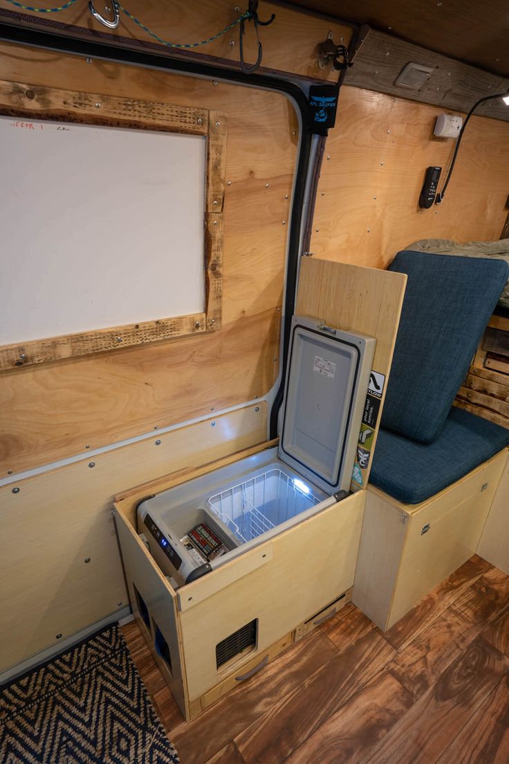 the inside of an rv with a small refrigerator