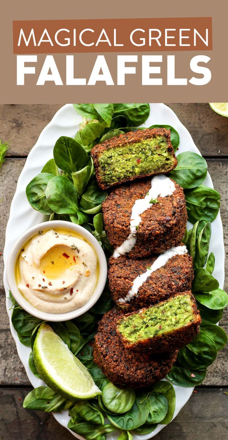 a white plate topped with falafels covered in lettuce and sauce