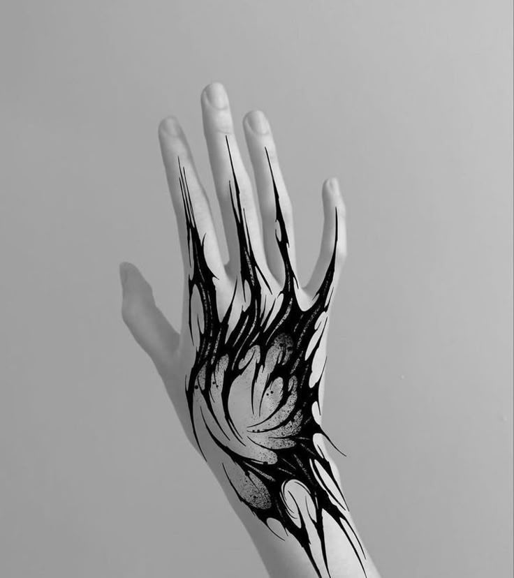 a person's hand with black and white ink on it, holding out their palm