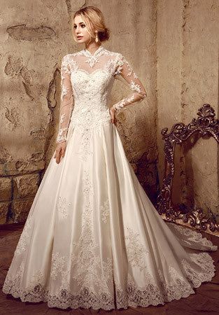 a woman in a white wedding dress standing next to a stone wall