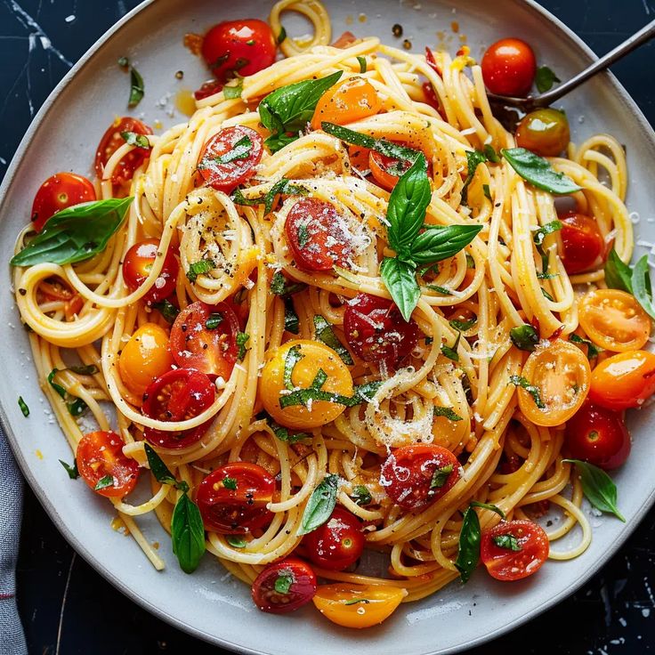 a white plate topped with pasta and tomatoes