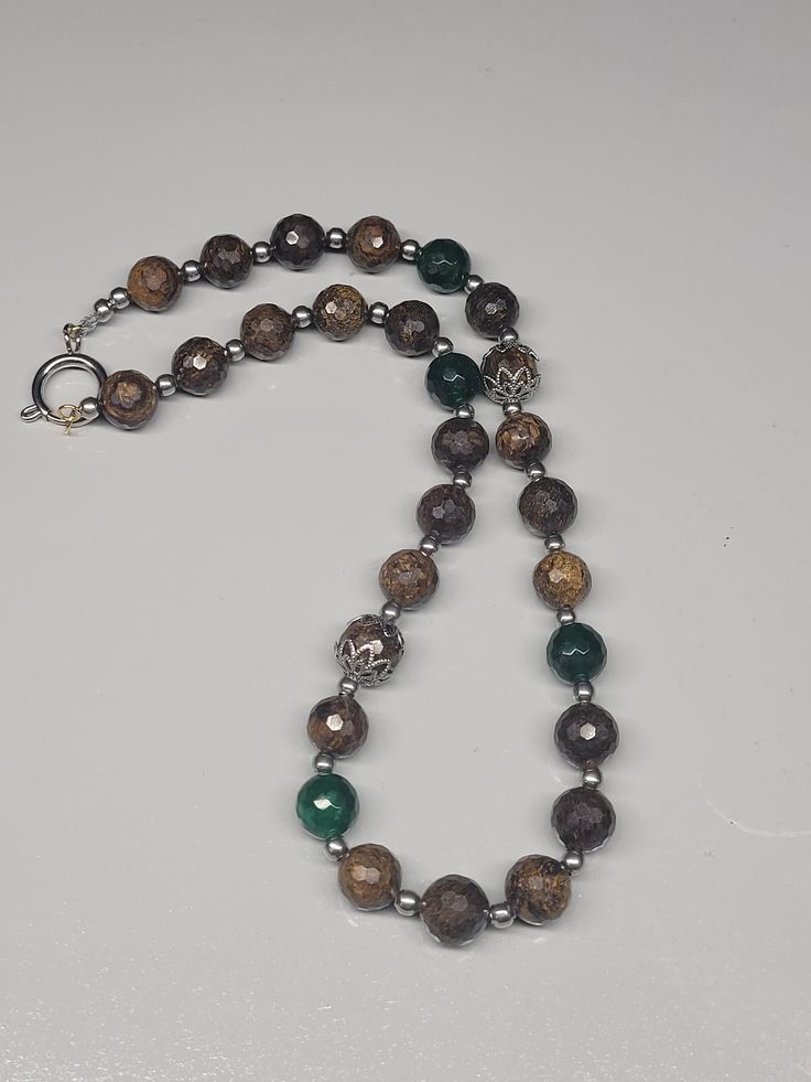 Very classy necklace featuring 10mm faceted bronzite and green jade gemstone round beads 15 inch long approx. Stainless steel seed beads and spring ring clasp Brown Beaded Necklace With Faceted Beads For Gifts, Brown Faceted Beads Necklace As Gift, Earthy 8mm Beads Necklace As Gift, Earthy Agate Beaded Necklaces With Round Beads, Brown Gemstone Beaded Jewelry, Gift Jasper Beaded Necklaces With Round Beads, Jade Beaded Necklaces With Faceted Beads, Brown Gemstone Beads Jewelry, Faceted Agate Beaded Necklaces With Round Beads