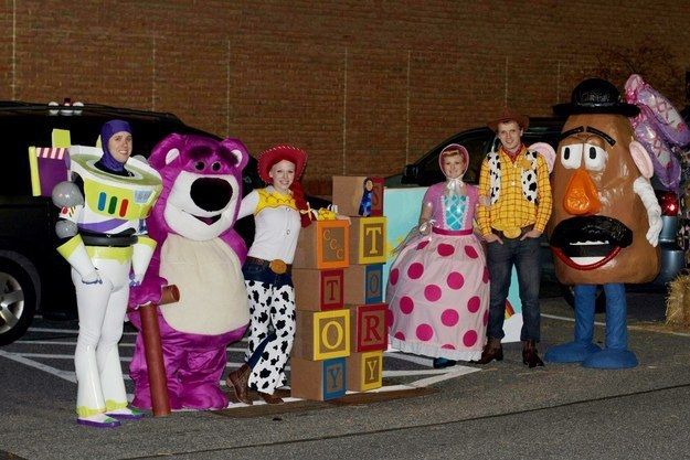 some people are dressed up in costumes and posing for a photo with the characters from toy story