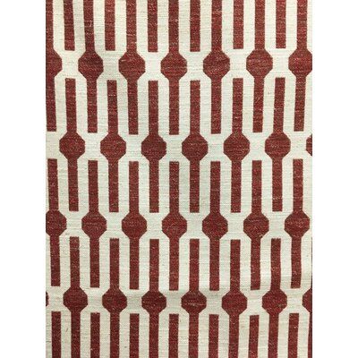 a red and white rug with an abstract design on the bottom, it is made out of