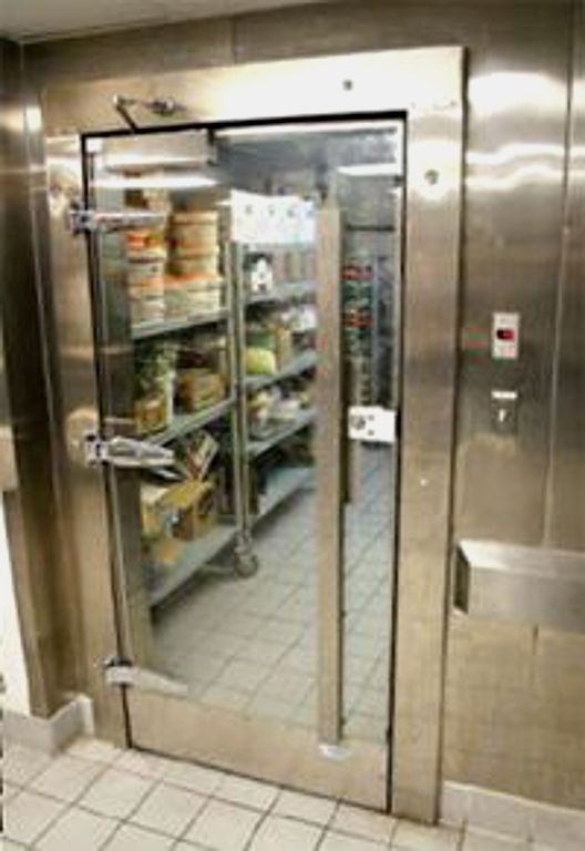 an industrial kitchen with stainless steel doors and shelves