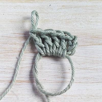 a close up of a piece of yarn on a wooden surface with the end knoted together