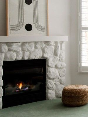 a living room with a fire place in the corner and a painting on the wall