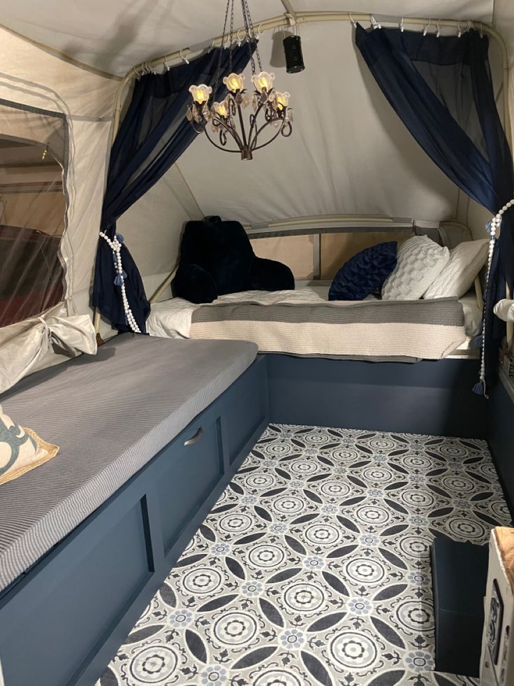 the inside of a tent with a bed and some pillows on it's side