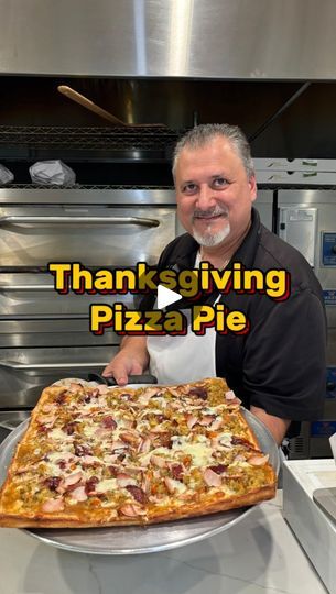 a man standing in front of a pizza on top of a metal pan with the words thank giving pizza pie