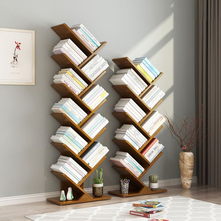 a bookshelf filled with lots of books on top of a white rug in a living room