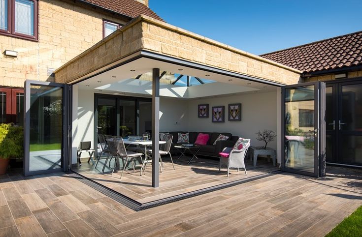 an outdoor patio with glass doors and furniture