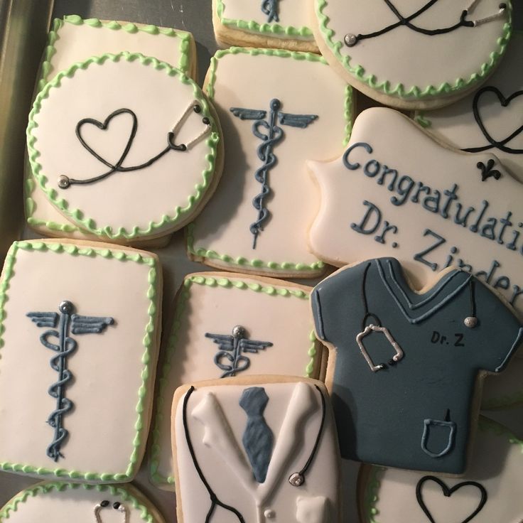 cookies decorated with medical symbols are arranged on a tray for a graduation party or celebration