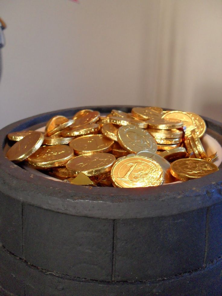 a pot filled with gold coins sitting on top of a table