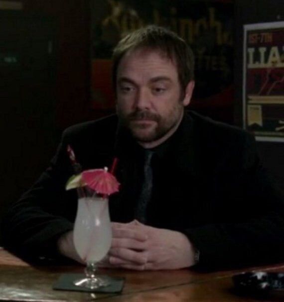 a man sitting at a table with a drink in front of him