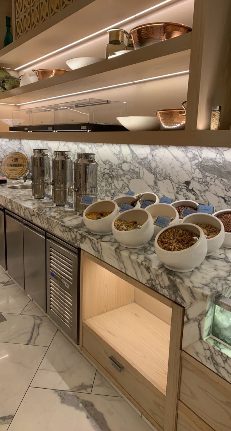 bowls of food are lined up on the counter in this modern looking kitchen area with stainless steel appliances