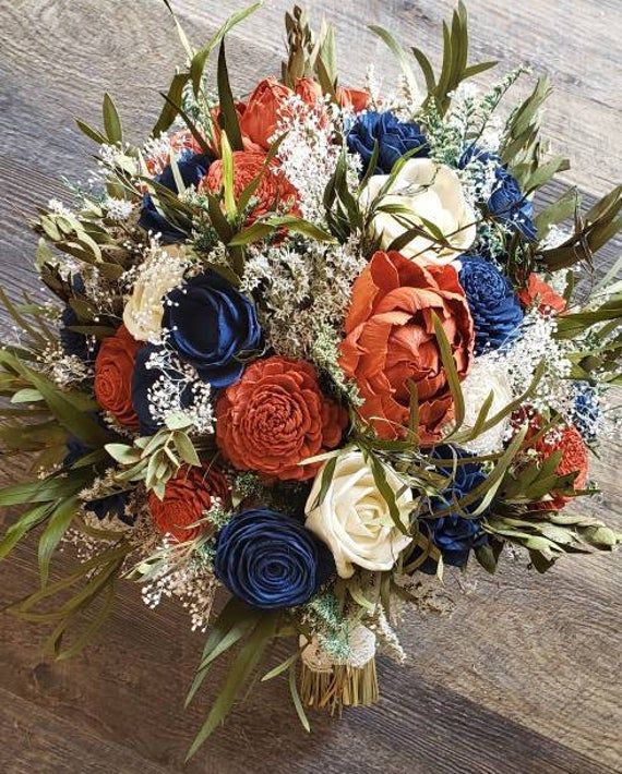 a bouquet of red, white and blue flowers sitting on top of a wooden table